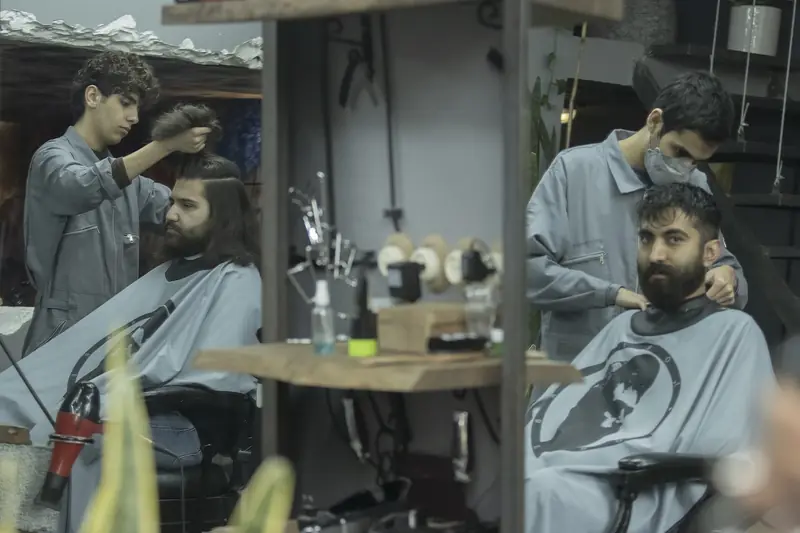 Kapster memotong rambut pelanggan